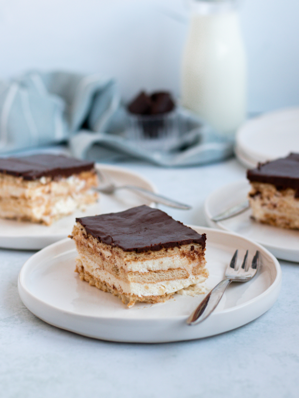 Sliced of eclair chocolate cake on white plates.