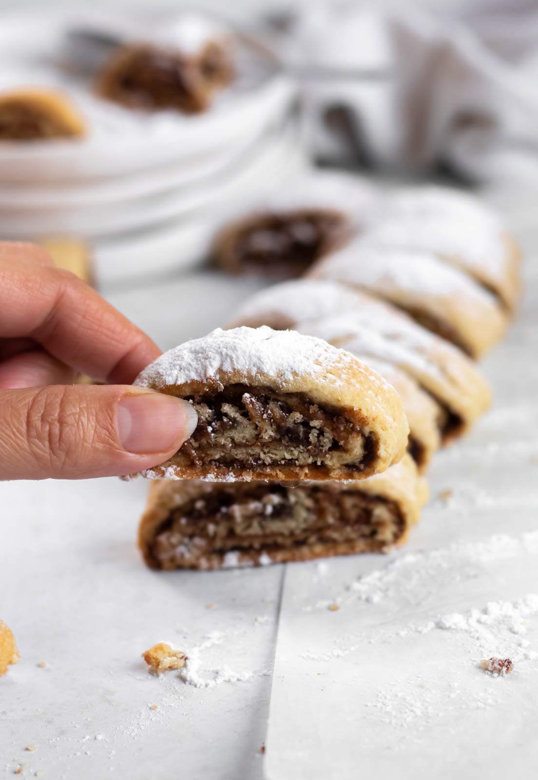 Hand holding a rolled date cookie.