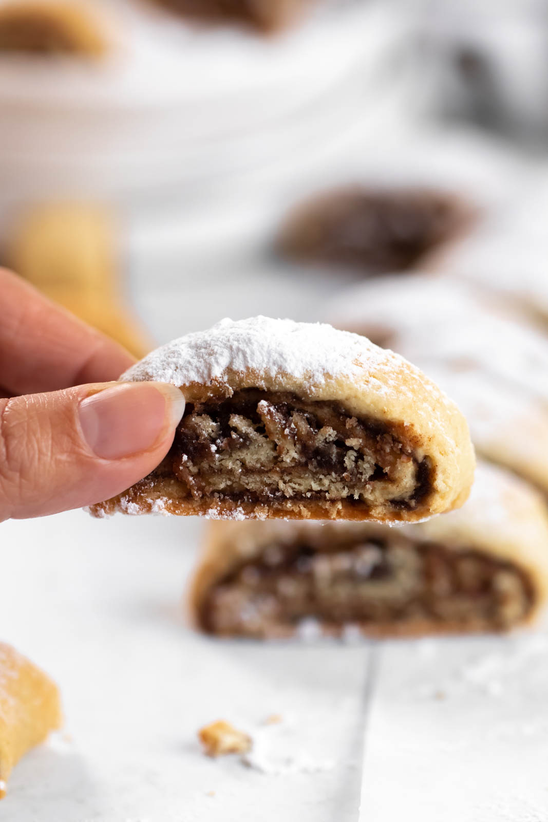Hand holding a rolled date cookie.