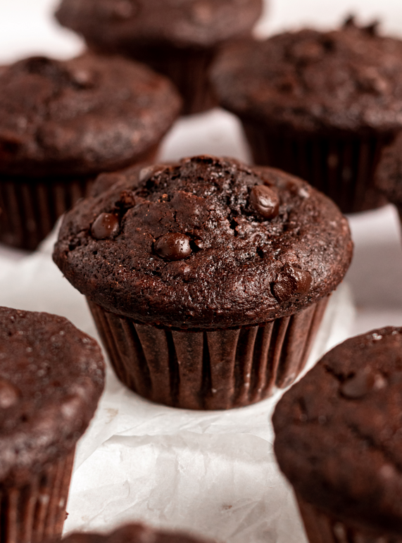 Moist double chocolate muffins on a parchment paper.