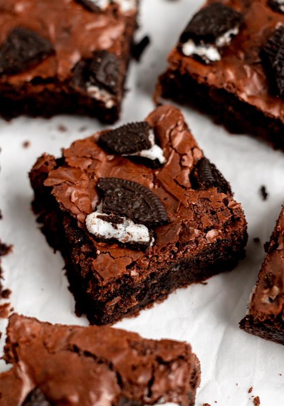 Slice of oreo brownies on a white parchment paper.