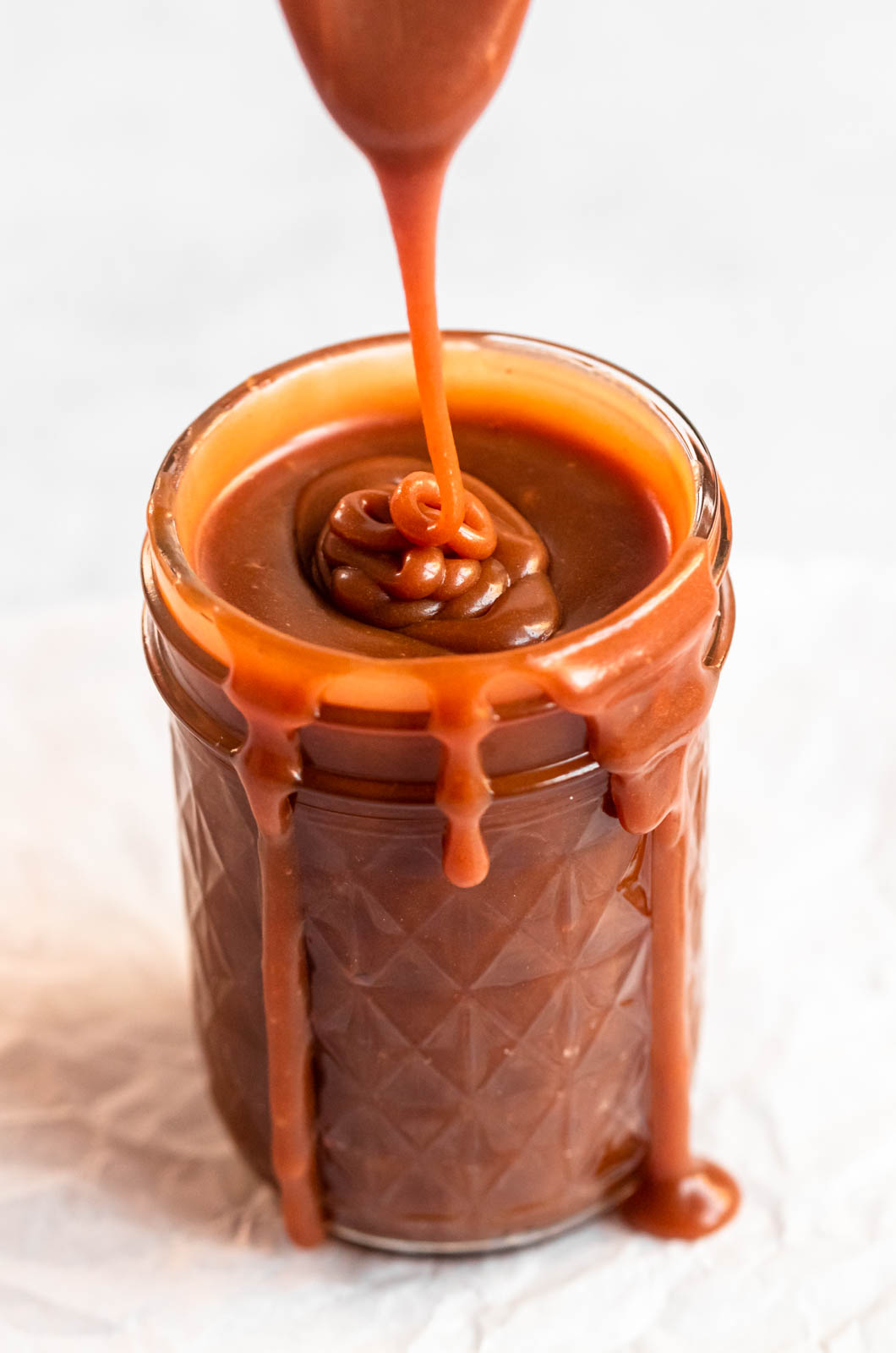 Salted caramel sauce poured into a mason jar.