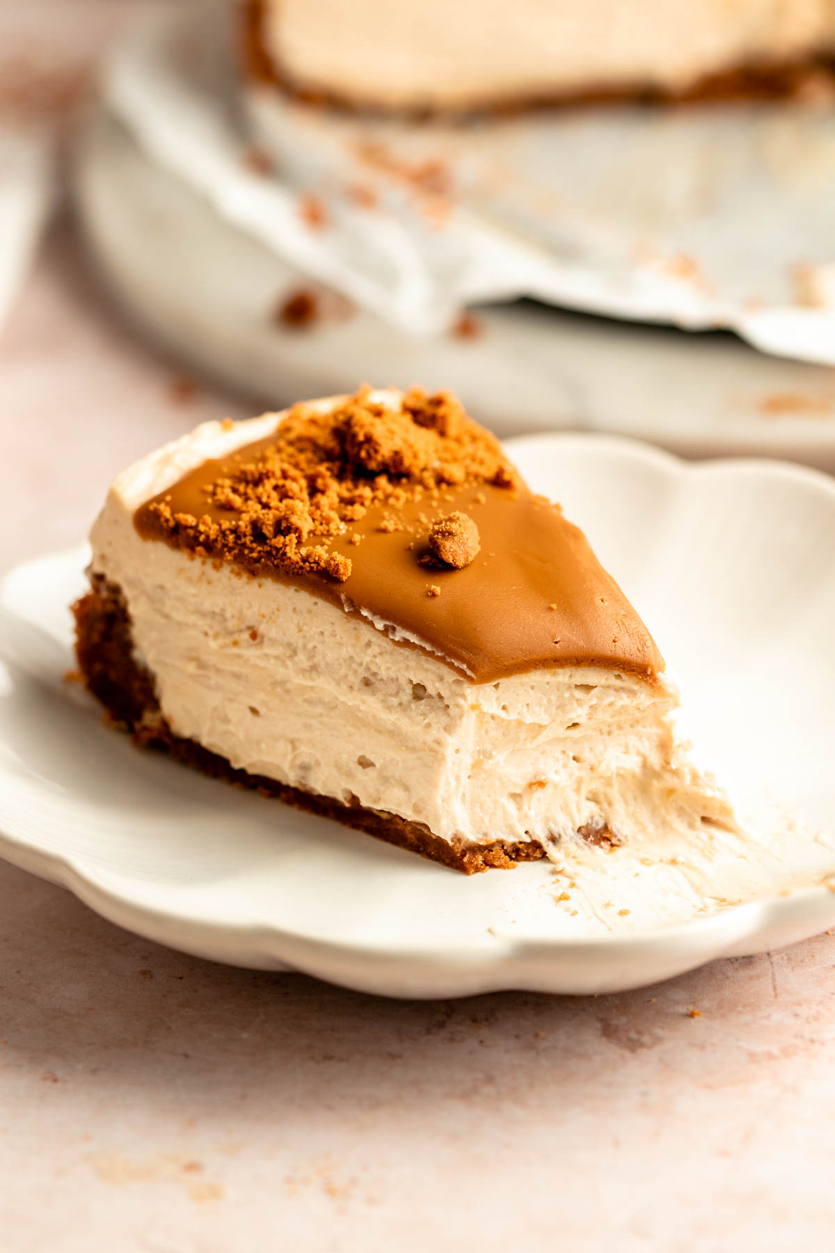 Slice of no bake biscoff cheesecake with a bite missing.