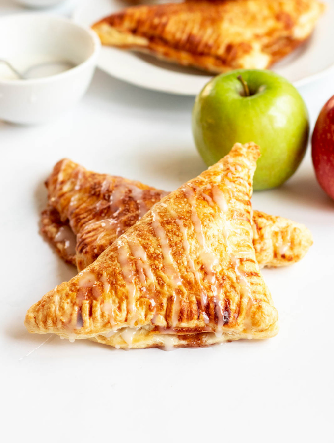 2 apple turnovers with fresh apples on the side