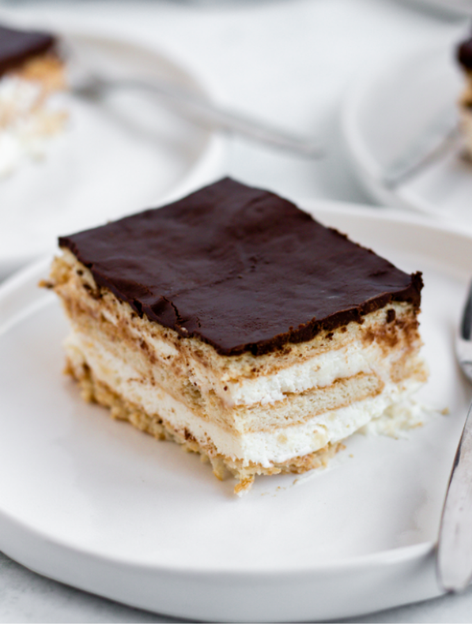 Slice of chocolate eclair cake on a white plate.