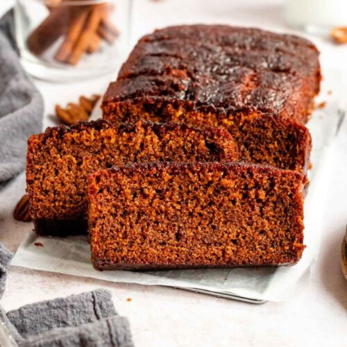 Sliced loaf of honey cake on a parchment paper.