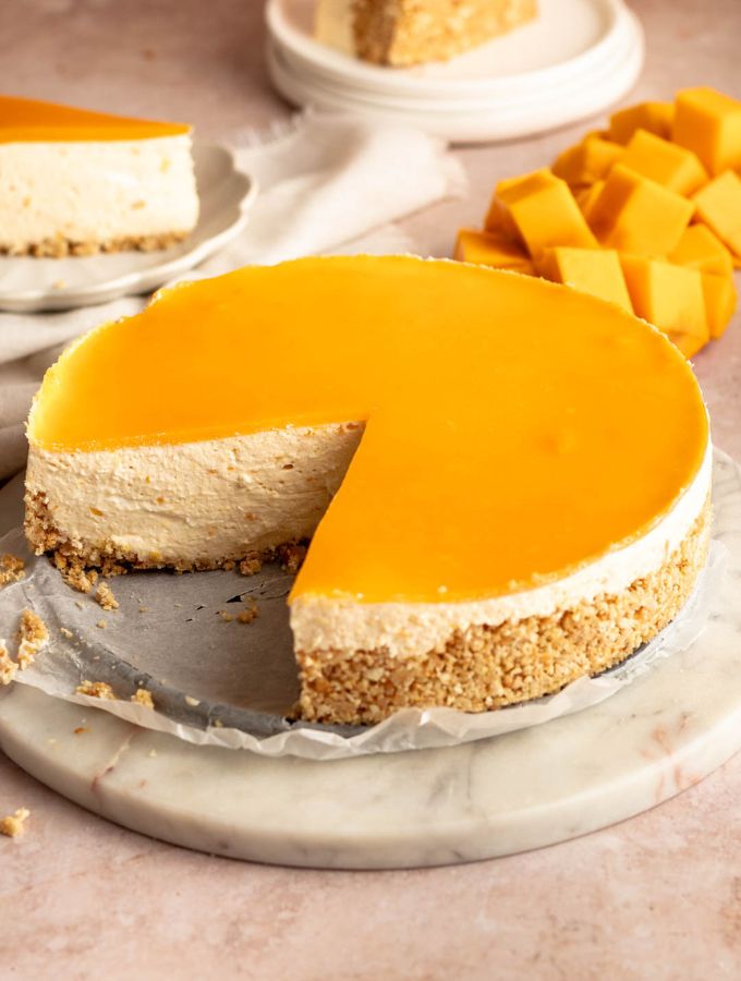 Slice missing from a no bake mango cheesecake.