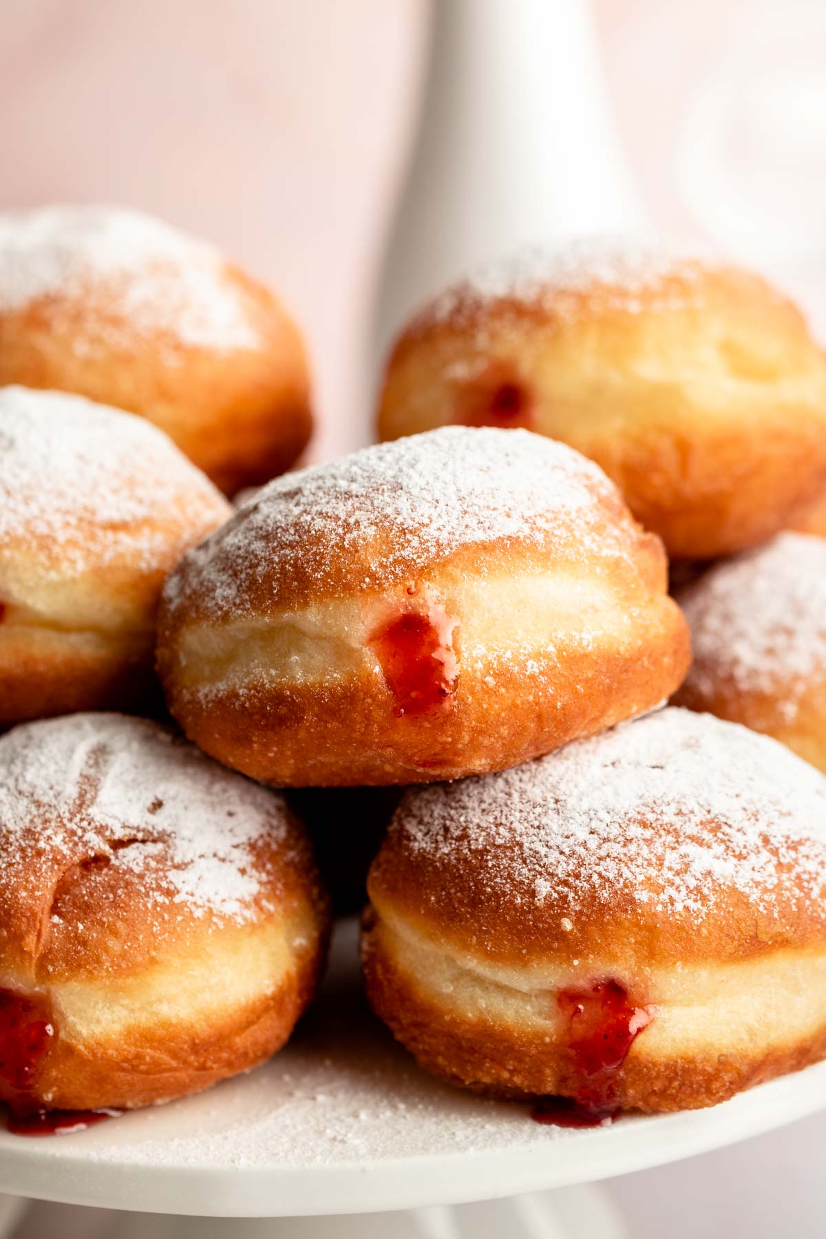 Stack of sufganiyot filled with strawberry jelly.