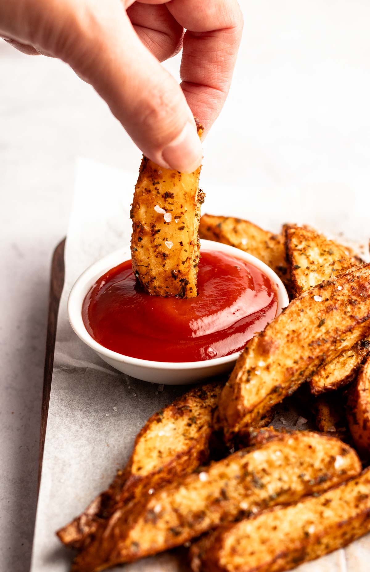Piece of potato dipped in ketchup.