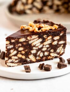 Slice of chocolate biscuit cake on a white plate.