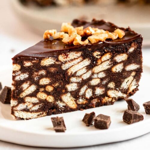 Slice of chocolate biscuit cake on a white plate.