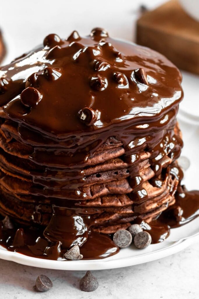 Close up shot of pancakes with chocolate ganache and chocolate chips.