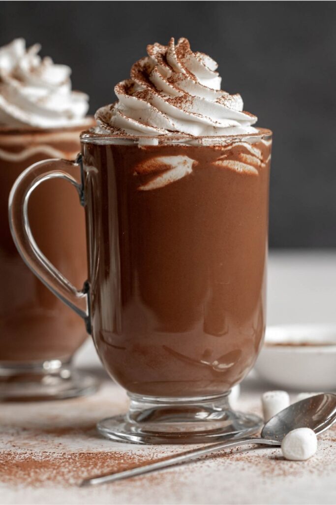 Two cups of french hot chocolat with whipped cream on top.