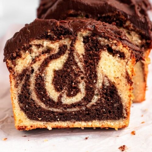 Marble loaf cake sliced on a parchment paper.