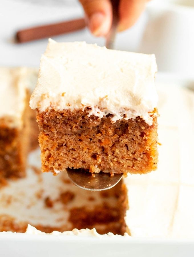 Slice of pumpkin cake with cream cheese frosting lifted from the pan.