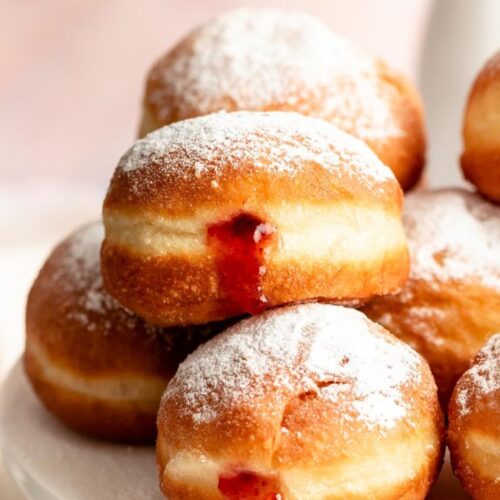 Stack of sufganiyot filled with strawberry jelly.