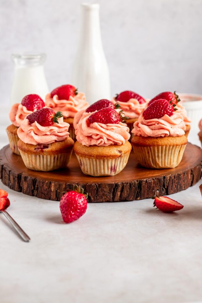 Strawberry filled cupcakes on a wooden surface.