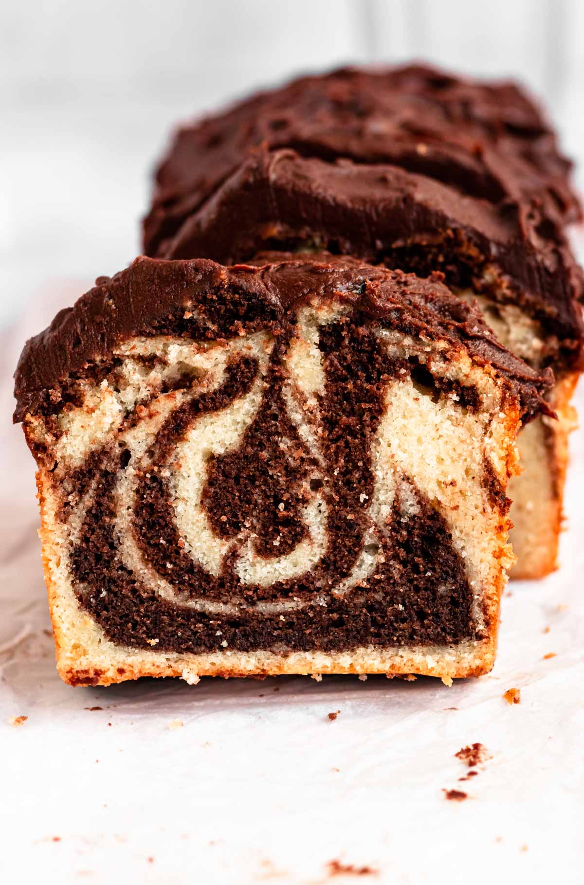 Slices of marble loaf cake on parchment paper.