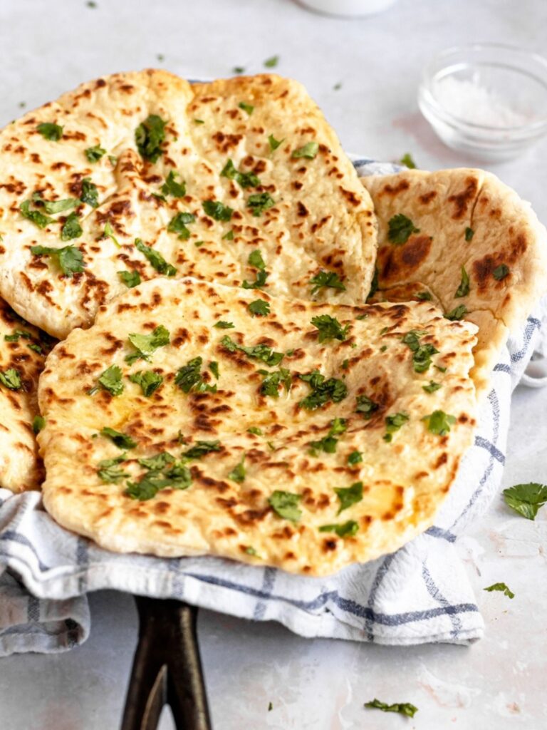 Naan bread with herbs on a towel.