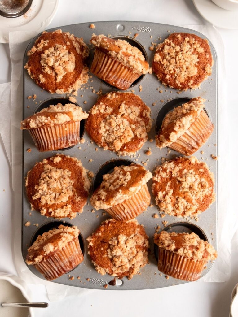 Overhead shot of muffins with crumble topping in muffin tin.