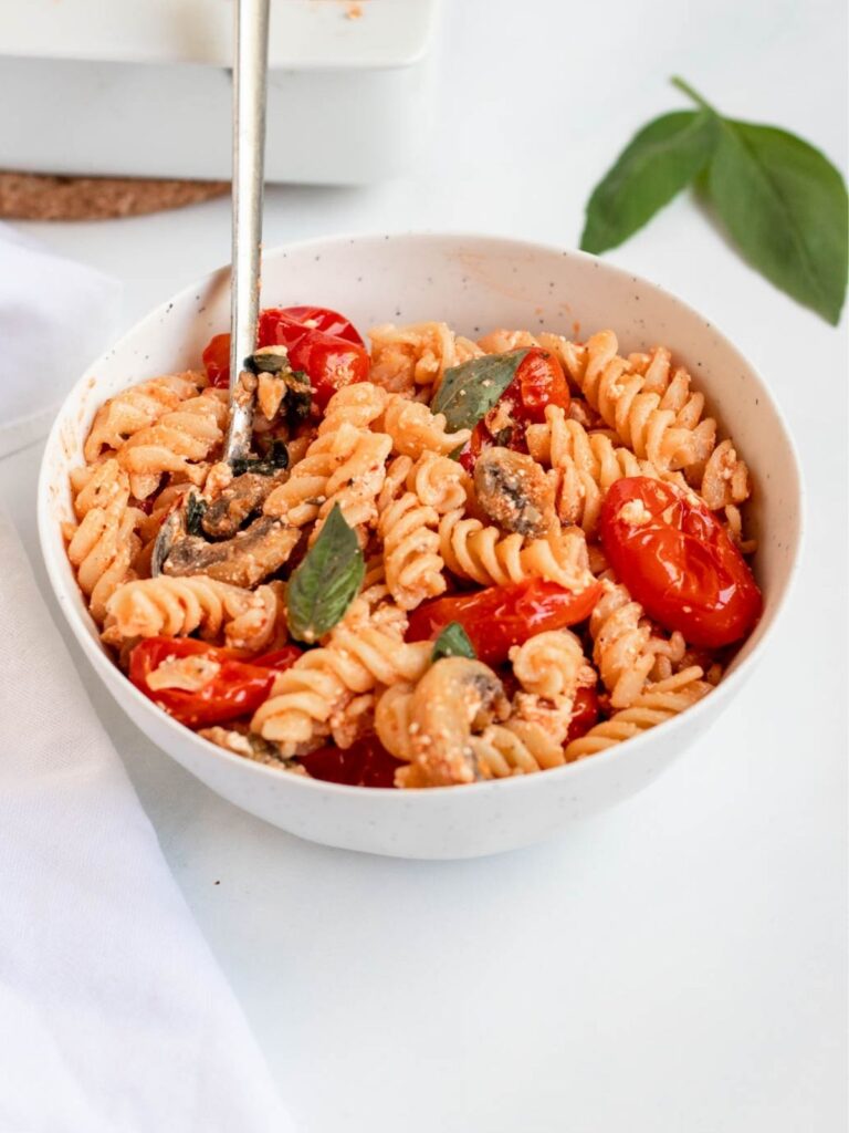 A bowl with pasta and tomatoes.