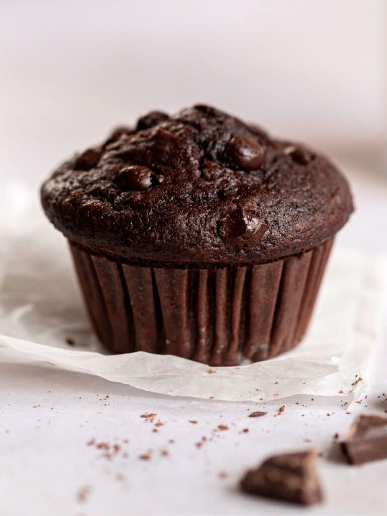 Triple chocolate muffins on a parchment paper.