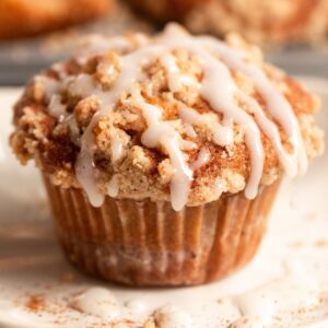 Coffee cake muffin on parchment paper with glaze on top.