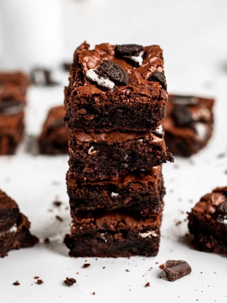 Stack of oreo brownies with crumbs around it.