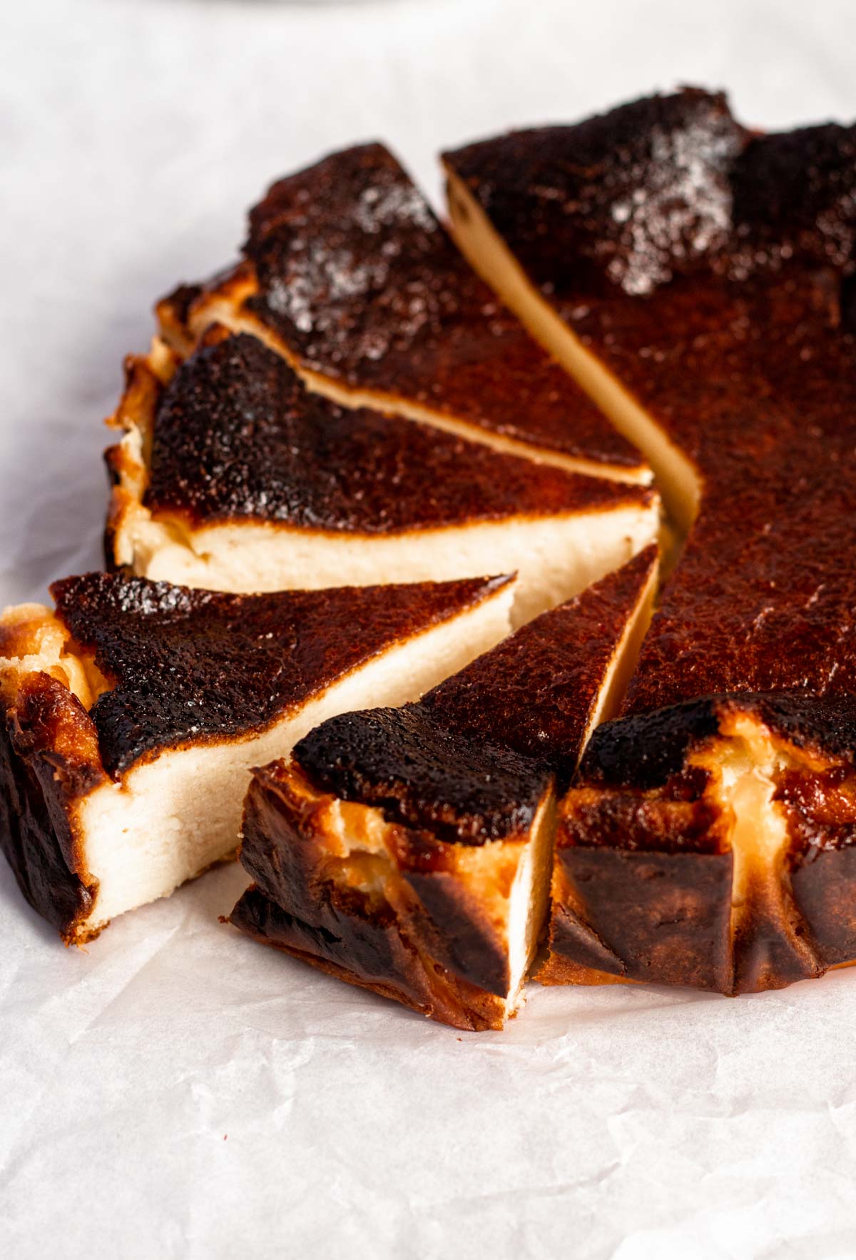 mini burnt cheesecake sliced on parchment paper.