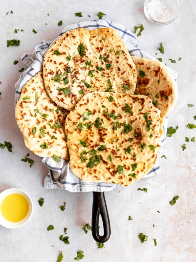 Flatbread on a pan with herbs and olive oil.