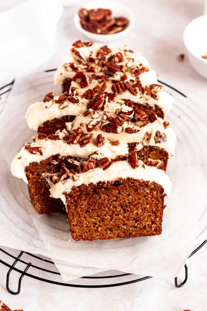 Sliced carrot cake loaf on a parchment paper.