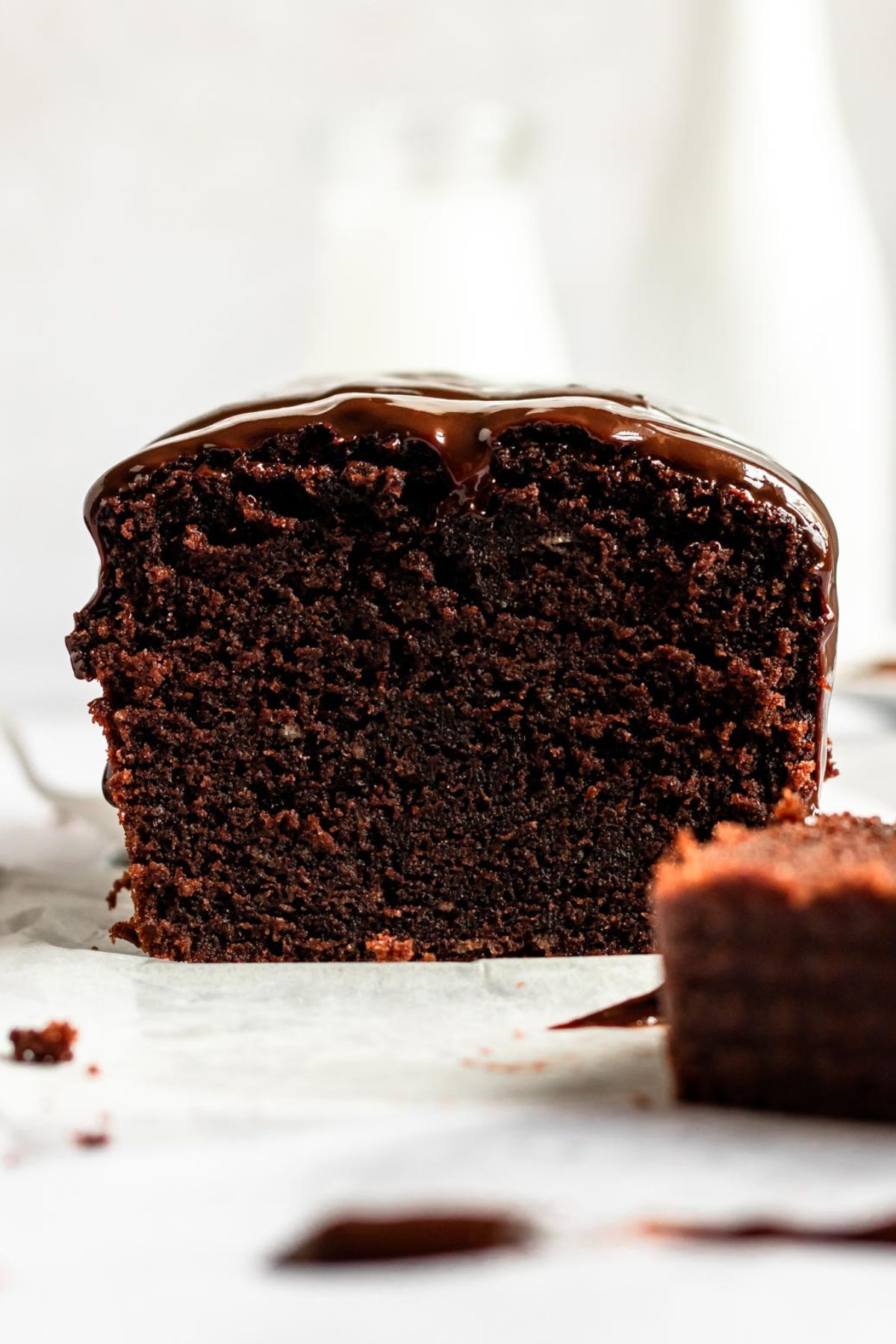 Close-up front view of a whole chocolate sour cream pound cake topped with a rich chocolate ganache glaze, highlighting its moist crumb.