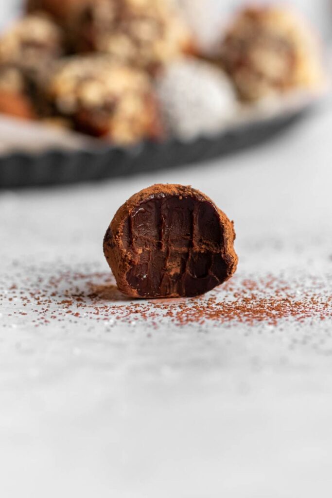 Single chocolate truffle with a bite missing.