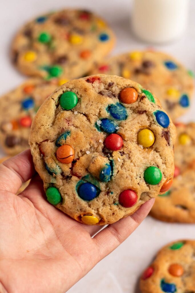 A hand holding a large cookie.