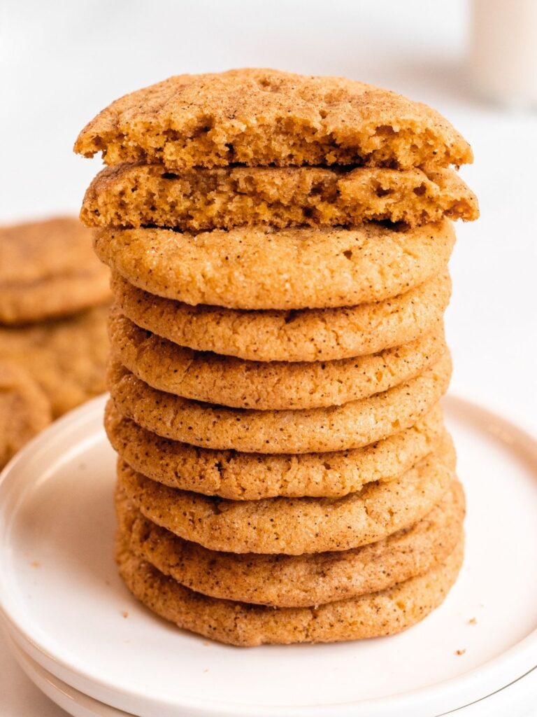 Stack of pumpkin snickerdoodle cookies with a cookie cut in half.