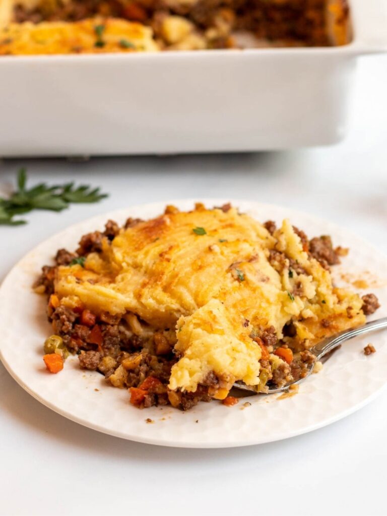 Serving of cottage pie on a white plate.