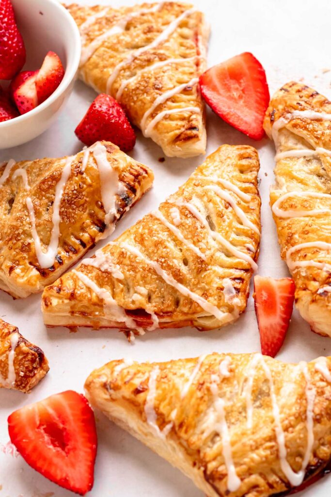 Overhead shot of turnovers with strawberries on the side.