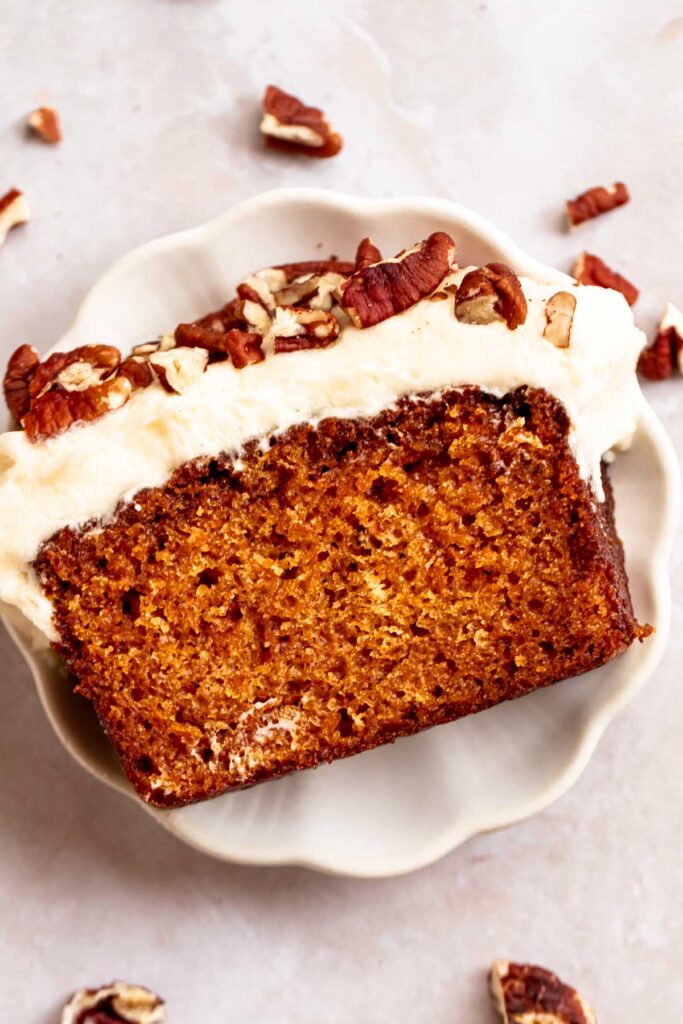Carrot loaf cake slice on a plate.