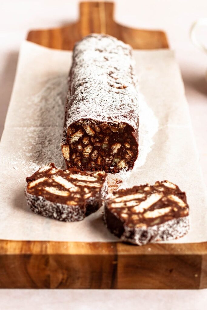 Roll of chocolate salami on parchment paper.