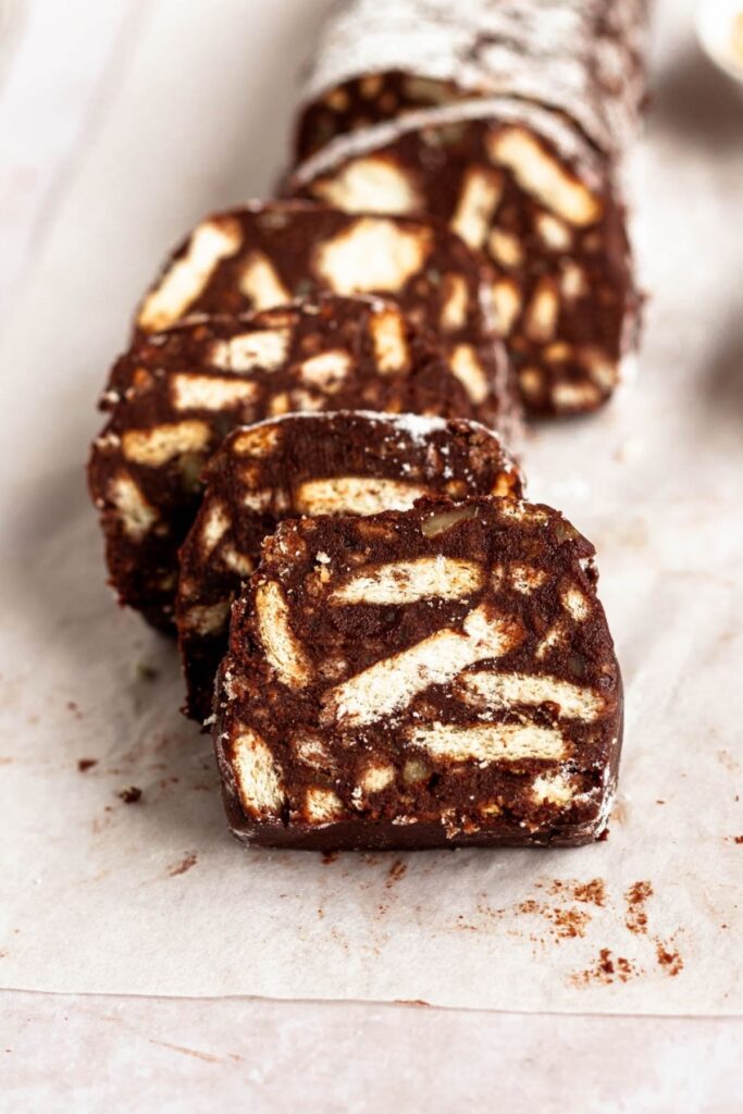 Slices of chocolate salami on parchment paper.