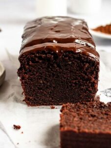 Sliced chocolate pound cake with sour cream on a parchment paper.