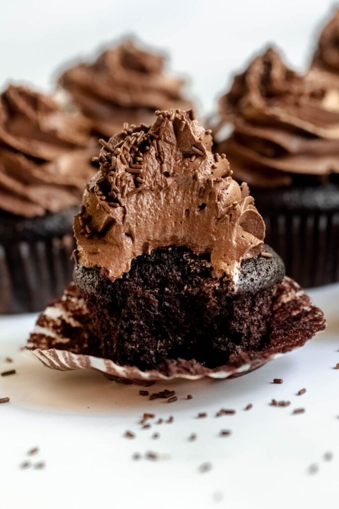 Bite missing from a chocolate cupcake.