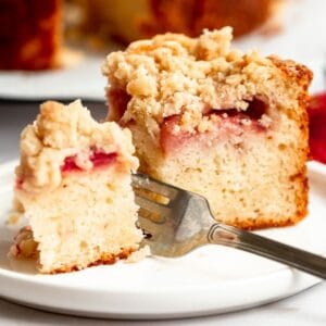 Slice of strawberry crumble cake with a fork inserted into the cake.