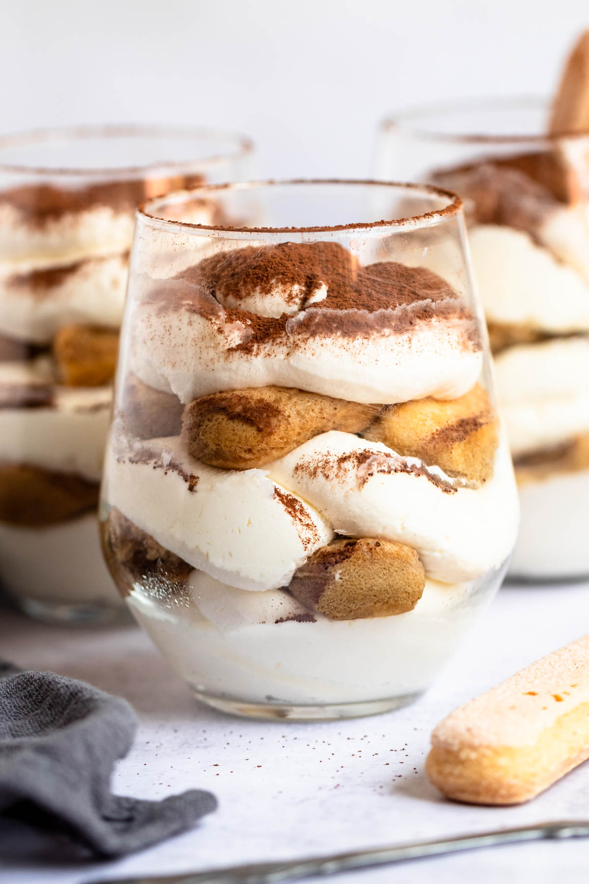 Three tiramisu cups on a white backround.