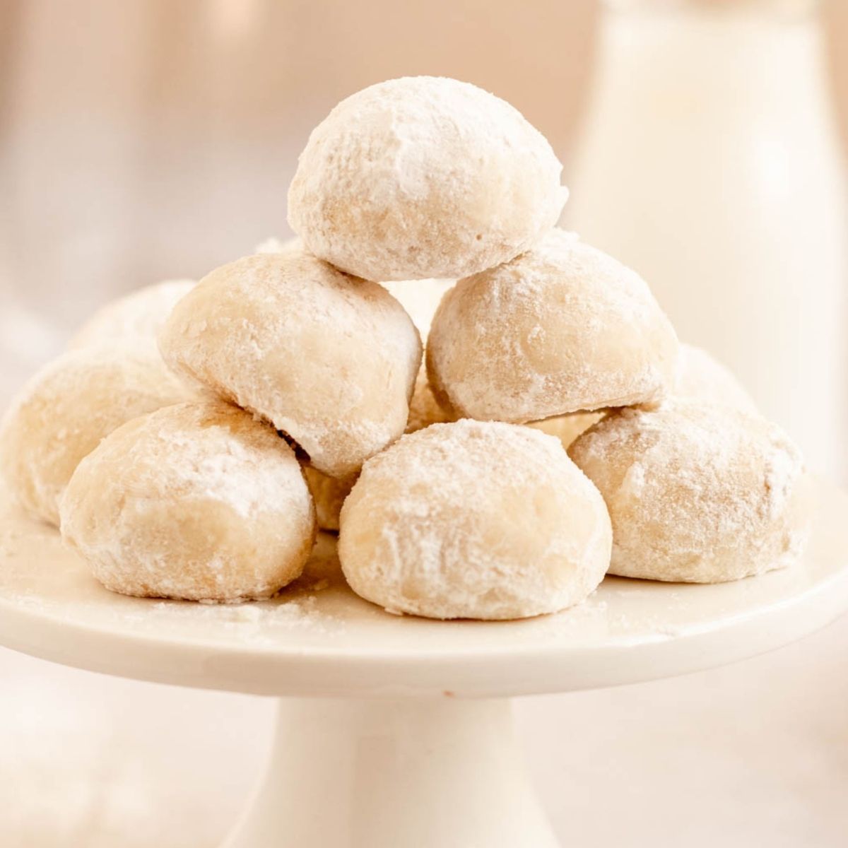 Almond snowball cookies on a small cake plate.