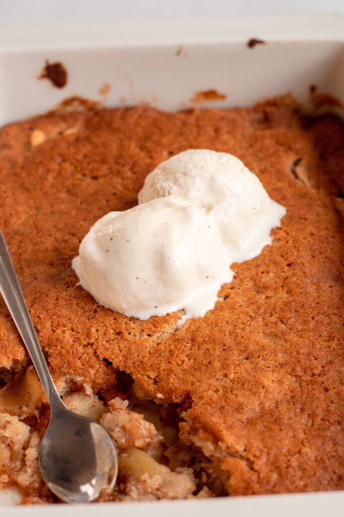 Close up shot of apple cobbler with a piece missing.