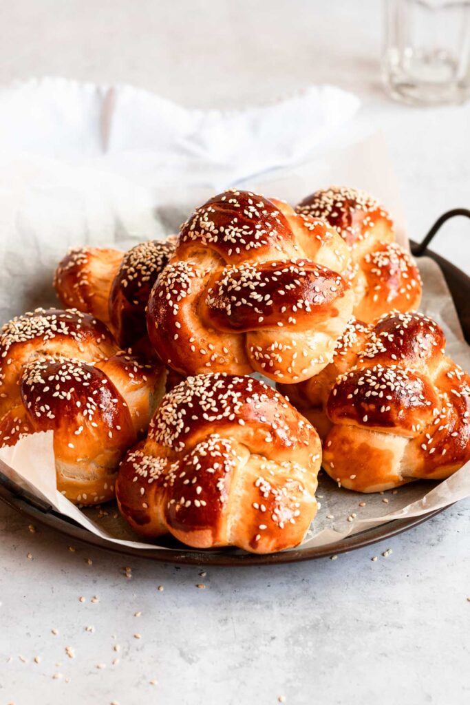 Pile of challah buns on a plate.
