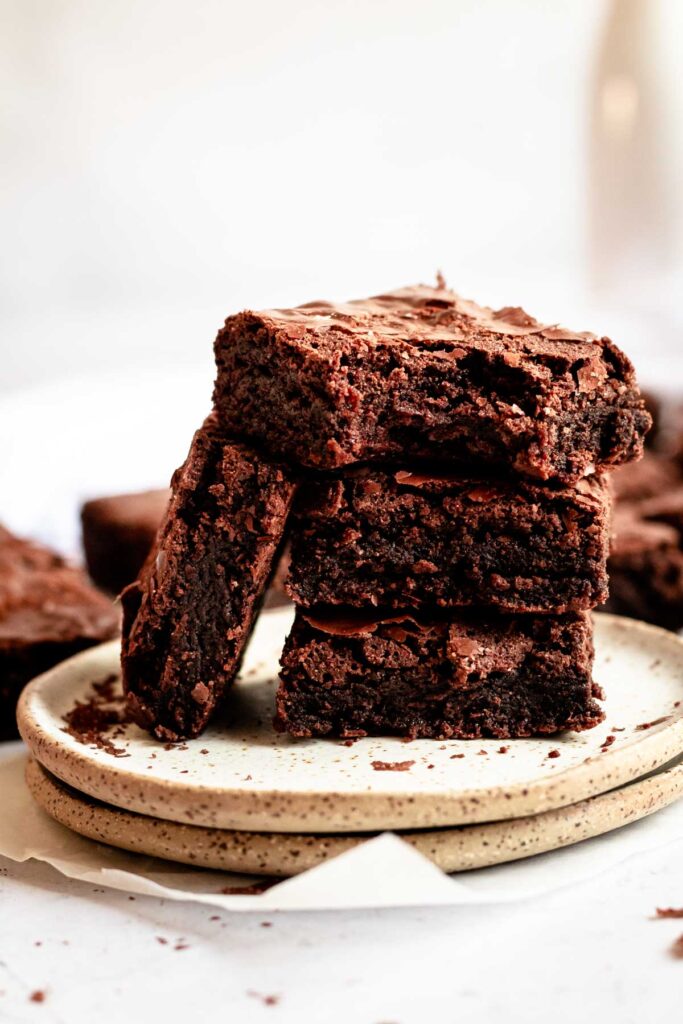 Stack of brownies with a bite missing from the top one.