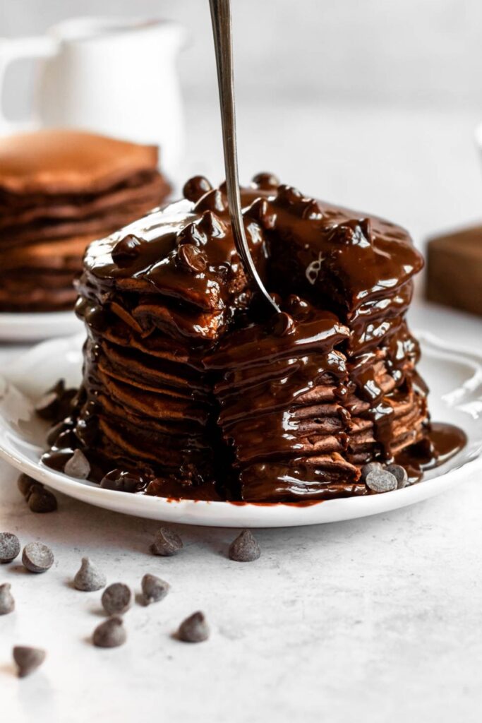 Fork inserted into a stack of pancakes.