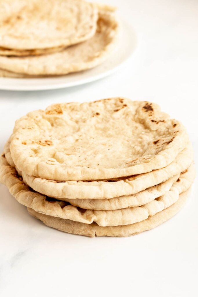 Stack of greek pita bread on a white backround.